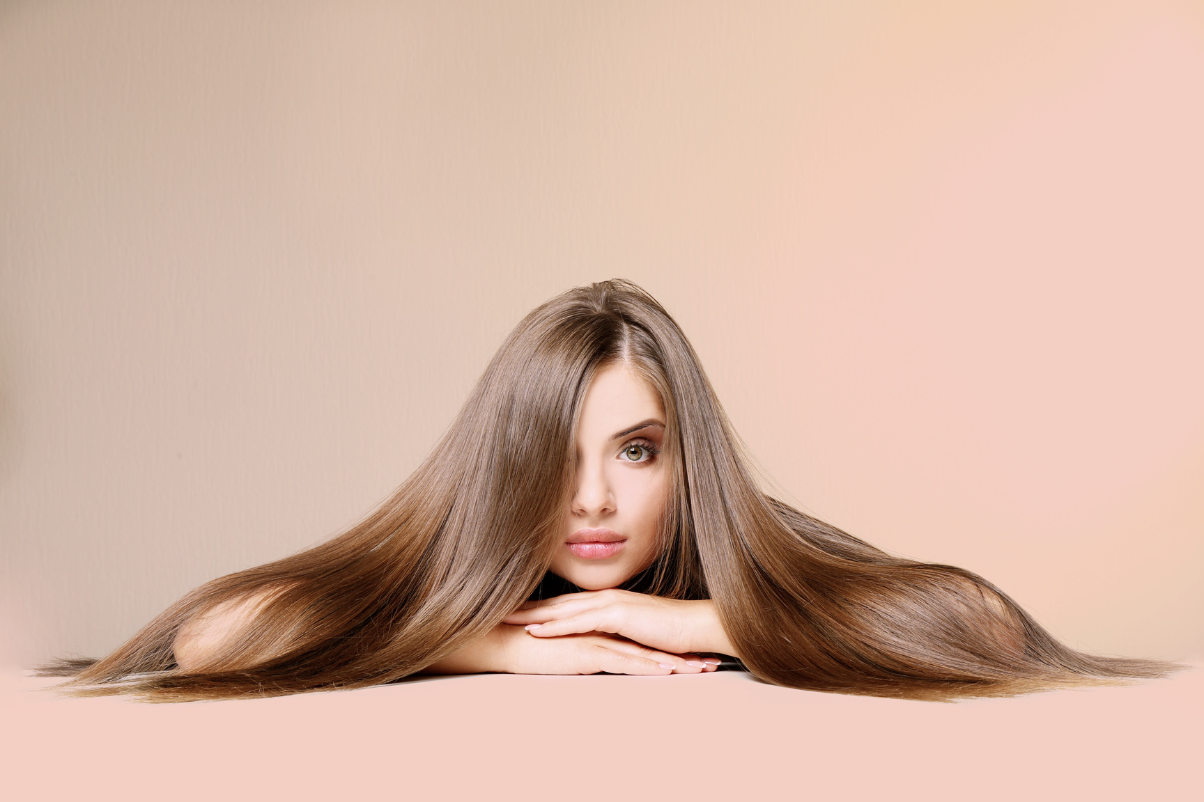 Young Woman with Healthy Hair on Peach  Background
